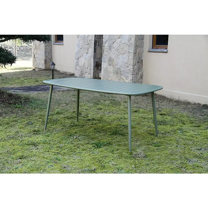 Mesa de jardín Noor - L x An x Al: 163 x 90 x 73 cm, Acero, Verde - Escena de jardín con una mesa de metal verde sobre un césped musgoso con una casa al fondo.