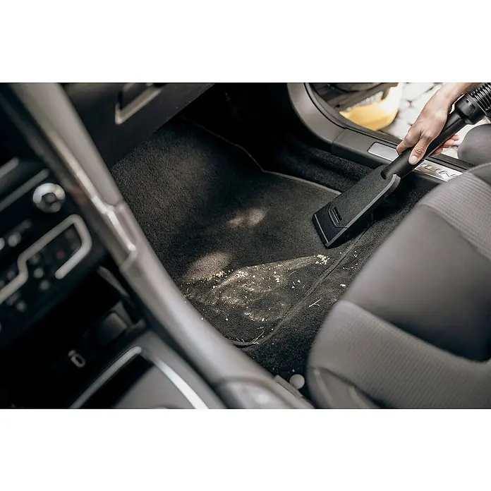 Kärcher Saugdüse - Passend für: Kärcher Nass-/Trockensauger, Geeignet für: Autos - Detailaufnahme eines Autos, in dem mit einem Staubsauger mit flachem Aufsatz der Fußraum von Schmutz befreit wird.
