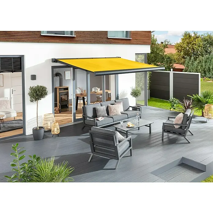 Sunfun Vollkassettenmarkise Elba - Gelb, Farbe Gestell: Anthrazitgrau, Breite: 5 m, Ausfall: 3,5 m - Terrassenbereich mit gelber Markise und grauen Gartenmöbeln. Die Markise spendet Schatten und schafft eine angenehme Atmosphäre.