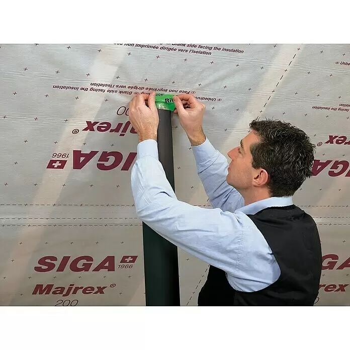 Siga Klebeband Rissan 60 - 15 m x 60 mm, Armierte Spezialfolie aus PE - Mann verklebt Rohrdurchführung mit grünem SIGA Rissan Klebeband auf SIGA Majrex 200 Dampfbremse.