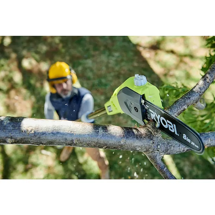 Ryobi ONE+ Podadora telescópica de batería OPP 1820 - 18 V, Sin batería, Longitud de la cuchilla: 20 cm - La motosierra de pértiga inalámbrica RYOBI recorta ramas en el jardín. El operador lleva casco con protección auditiva por seguridad.