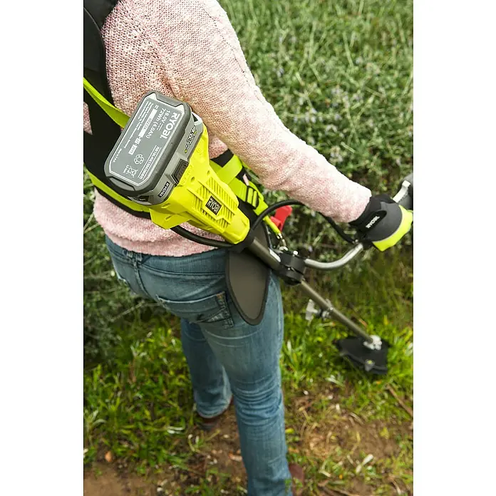 Ryobi ONE+ Akku-Rasentrimmer RBC 18X20B4F - 18 V, 4 Ah, Li-Ionen, 1 Akku, Schnittbreite Messer: 20 cm, Schnittbreite Faden: 30 cm - Eine Person bedient einen Ryobi Akku-Rasentrimmer mit Tragegurt im Garten.