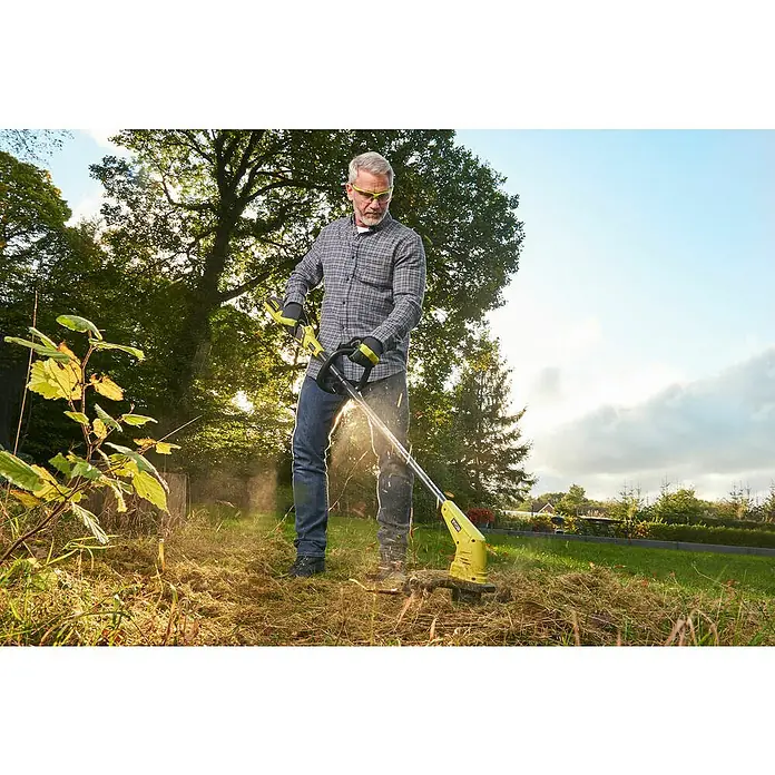 Ryobi Akku-Rasentrimmer RY36LT33A-120 - 36 V, 2 Ah, Li-Ionen, 1 Akku - Ein Mann benutzt einen gelben Ryobi Rasentrimmer, um hohes Gras zu schneiden, mit Bäumen im Hintergrund.
