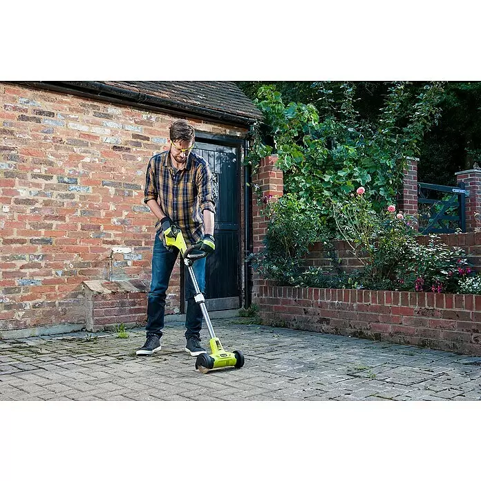 Ryobi ONE+ Limpiador de juntas de batería RY18PCA-0 - 18 V, Iones de litio, Sin batería - Hombre con camisa a cuadros limpia un patio pavimentado con un cepillo para malas hierbas amarillo y negro.