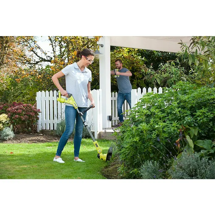 Ryobi ONE+ Hybrid-Rasentrimmer RLT1831H25F - 18 V, 2,5 Ah, Li-Ionen, 1 Akku - Eine Frau verwendet einen gelben Rasentrimmer, während ein Mann im Hintergrund arbeitet. Im Fokus steht der Akku-Rasentrimmer.