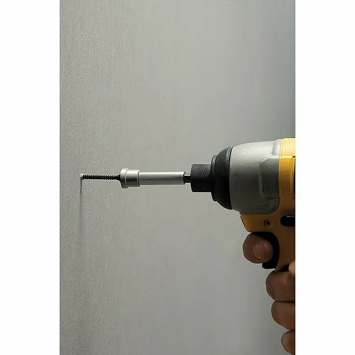 Stanley Bit Trockenbau STHT0-16137 - Passend für: 8/10 mm Bohrfutter - Nahaufnahme eines gelben und silbernen Akkuschraubers, der eine Schraube in eine graue Wand schraubt, ideal für Heimwerkerprojekte.