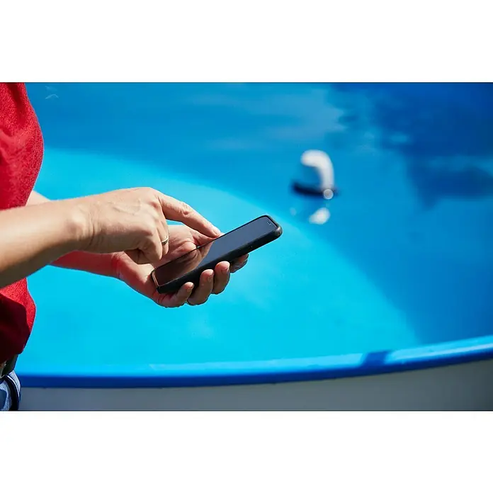 Fluidra Blue Connect Wasser-Analysegerät - Steuerung per Smartphone-App - Eine Person tippt auf ein Smartphone, das von einer schwarzen Hülle geschützt wird. Der blaue Hintergrund lässt das Handy hervorstechen.