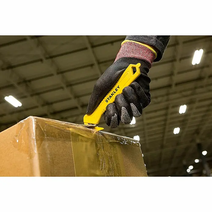Stanley Sicherheitsmesser Light STHT10355-1Gebogen, 165 mm - Eine Hand mit einem schwarzen Arbeitshandschuh öffnet eine Kiste mit einem gelben Stanley-Messer.