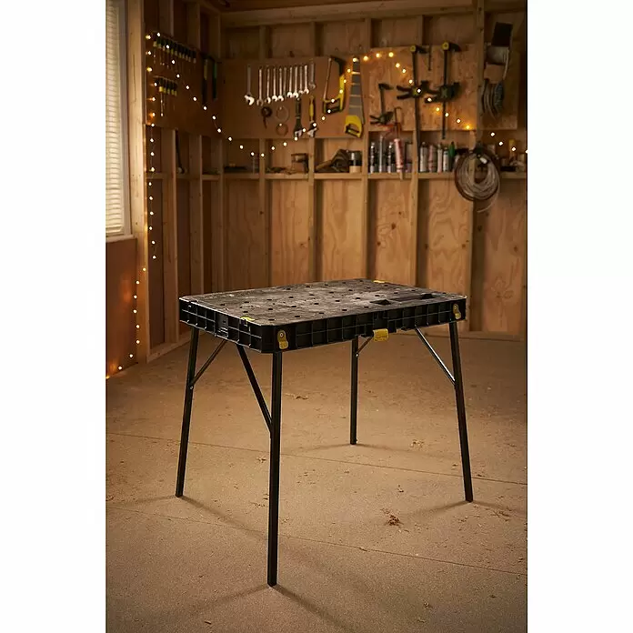 Stanley Werkbank ESSENTAIL™ STST83492-1 - L x B: 85 x 61 cm, Arbeitshöhe: 80 cm, Belastbarkeit: 320 kg, Schwarz/Gelb - Schwarze klappbare Werkbank mit gelben Akzenten in einer gemütlichen Werkstatt.
