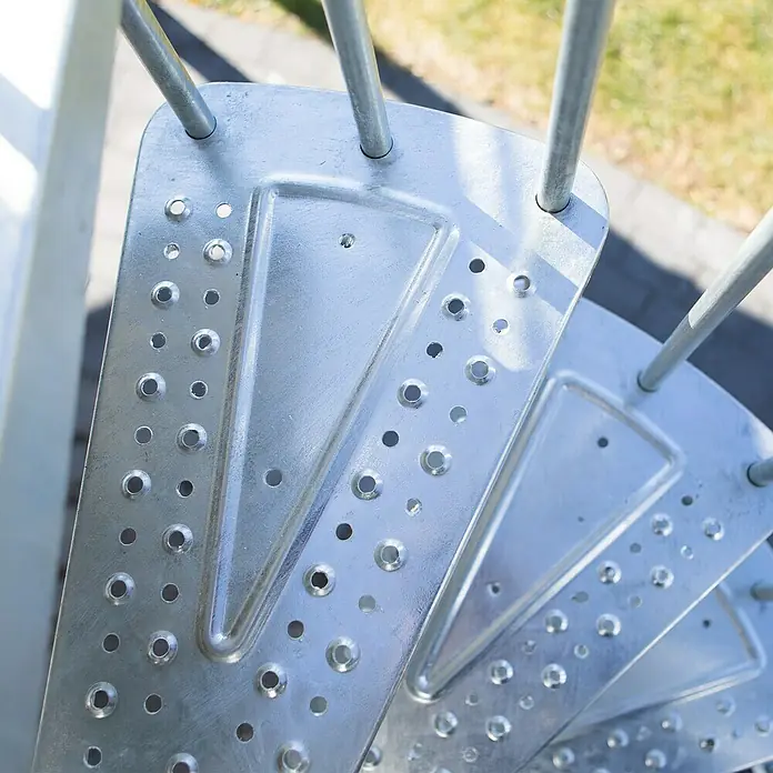 Dolle Außentreppe Gardenspin - Durchmesser: 185 cm, Geschosshöhe: 307,5 cm - 352,5 cm, Lochblechstufen, Silber - Detailaufnahme einer spiralförmigen Metalltreppe mit gelöcherten Stufen, die Stabilität und Rutschfestigkeit bieten. Ideal für den Außenbereich.