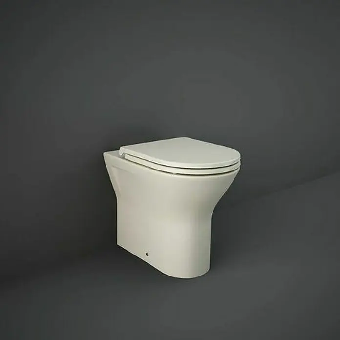 RAK Ceramics Feeling Stand-WCSpülrandlos, Ohne Spezialglasur, Spülform: Tief, WC Abgang: Waagerecht, Greige - Das Bild zeigt eine moderne, bodenstehende Toilette in einem schlichten Design vor einem dunklen, neutralen Hintergrund. Die Toilette ist in Weiß gehalten.