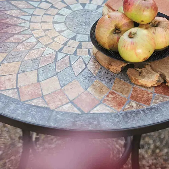 Siena Garden Balkontisch rund Prato - Ø x H: 70 x 70 cm, Schwarz/Braun - Nahaufnahme eines Mosaiktisches mit Äpfeln auf einem dekorativen Teller, der das rustikale und künstlerische Design des Tisches hervorhebt.
