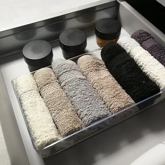 Artysan Mueble bajo de lavabo Tina Paris - An x Pr x Al: 80 x 46 x 64 cm, Blanco - Organización ordenada de cajones con una caja de almacenamiento transparente, que contiene toallas coordinadas por colores y frascos de crema.