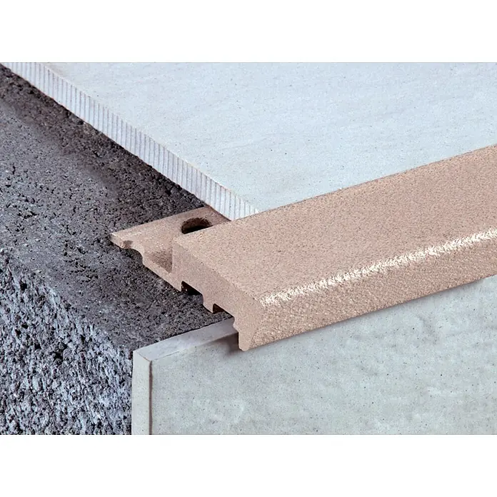 Perfil para baldosas para peldaño - Marrón, 2,5 m x 12,5 mm - Un primer plano muestra una elegante tira de transición que conecta dos revestimientos de suelo diferentes para un acabado.