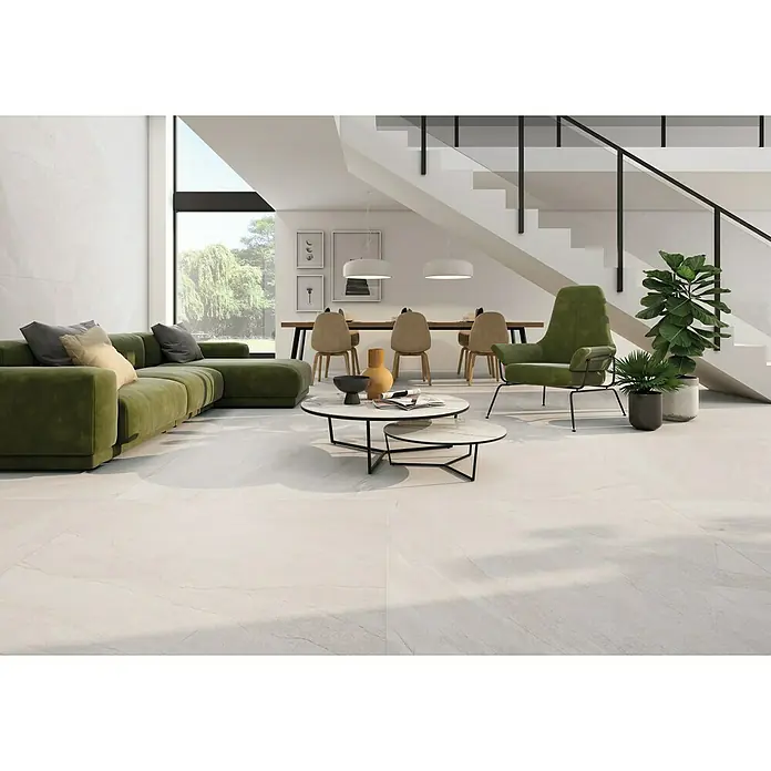 Pavimento porcelánico Halley - 30 x 60 cm, Light, Mate, Rectificado - La imagen muestra un espacio de estar moderno con pisos de baldosas claras, un sofá verde, un sillón verde, una mesa de café y escaleras.