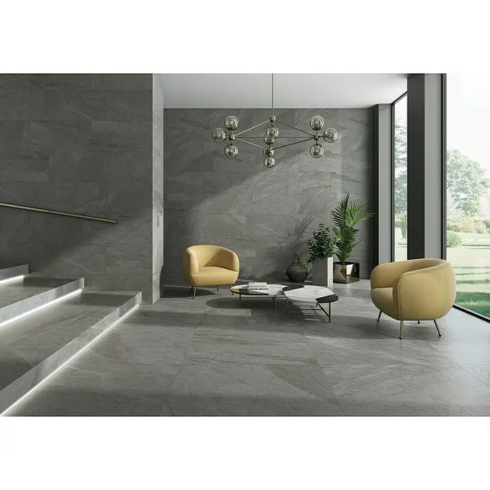 Pavimento porcelánico Halley - 30 x 60 cm, Silver, Mate, Rectificado - Elegante interior con baldosas grises que crean un ambiente moderno. Dos sillones amarillos y una lámpara elegante complementan el diseño.