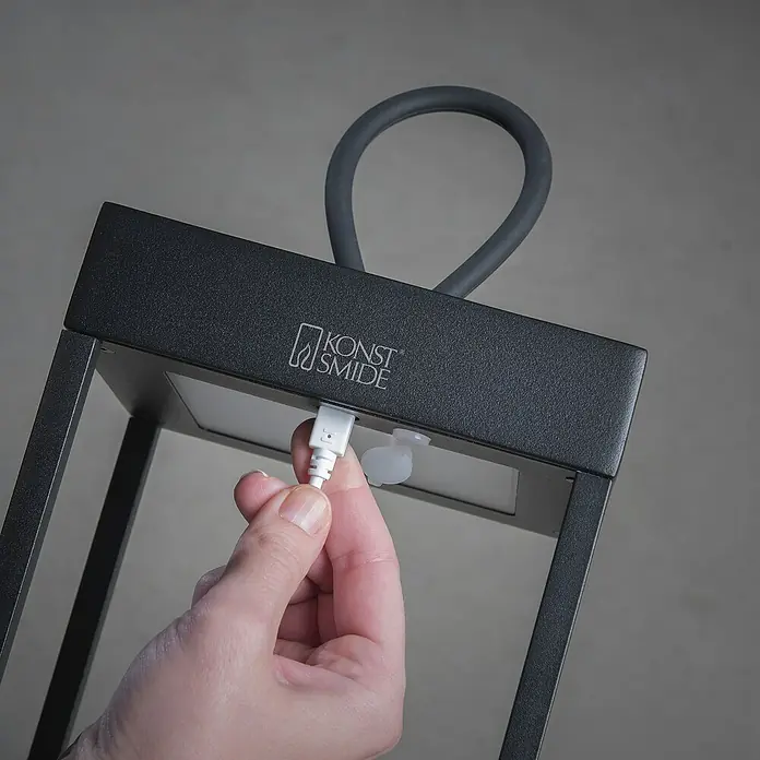Konstsmide Außenlaterne Ravello -  - Nahaufnahme einer Konstsmide Laterne, die mit einem USB-Kabel aufgeladen wird, um ihre Leuchtkraft zu erhalten.