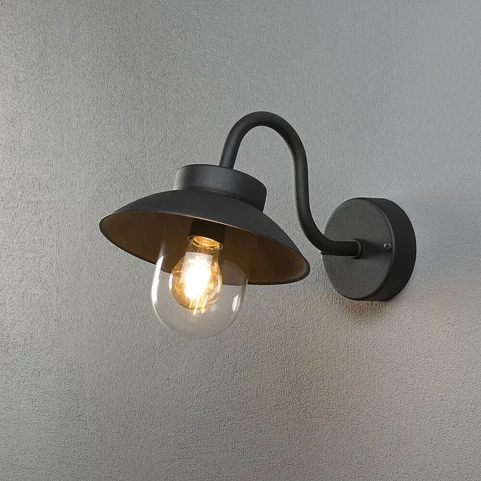 Konstsmide Außenwandleuchte Vega Mini - 60 W, Schwarz, IP44 - Eine elegante schwarze Wandleuchte mit einer klaren Glühbirne und einem goldenen Reflektor, die ein warmes Licht ausstrahlt.
