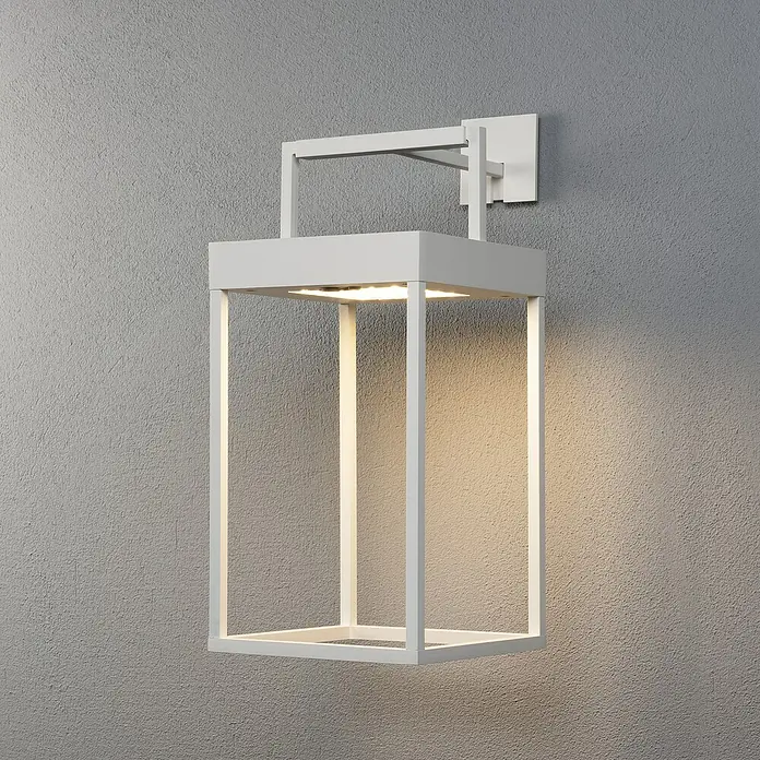 Konstsmide Außenlaterne Portofino - 15,5 x 18,5 x 30 mm, Weiß - Weiße, moderne Außenwandleuchte mit rechteckigem Rahmen und warmem Lichtschein an einer grauen Wand. Stilvolle Beleuchtung für den Außenbereich.