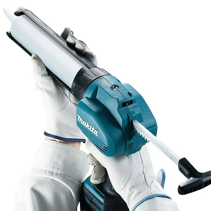 Makita LXT 18V Akku-Kartuschenpresse DCG180ZX - 18 V, Li-Ionen, Ohne Akku - Akkubetriebene Kartuschenpistole von Makita in den Händen einer Person mit weißen Handschuhen.