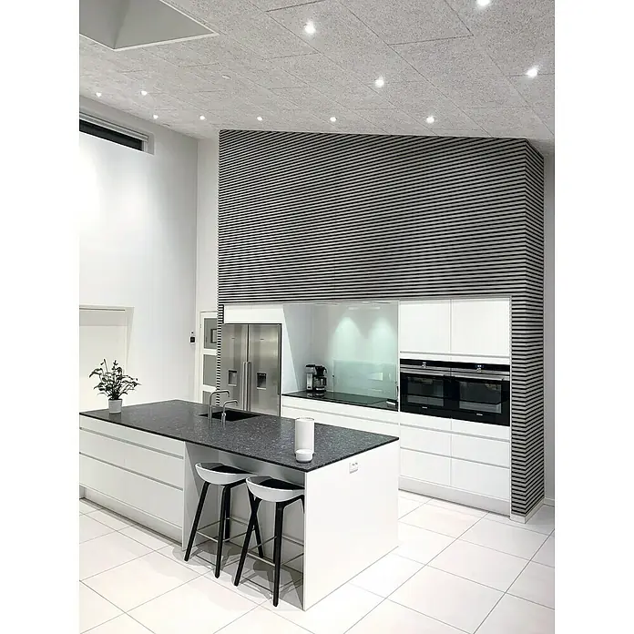 FibroTech Akustikplatte Multi Fein - Fein Weiß, 1.200 x 600 x 25 mm, 0,72 m² - Küchenaufnahme mit Kochinsel, modernen Stühlen und Einbaugeräten. Die helle Farbgebung und die Akzentwand sorgen für ein stilvolles Ambiente.