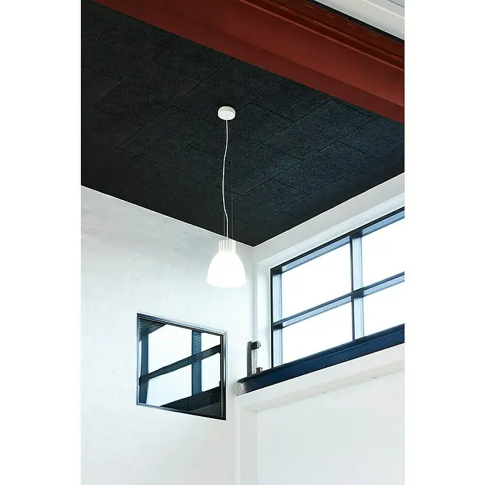 FibroTech Akustikplatte Multi Fein - Fein Schwarz, 1.200 x 600 x 25 mm, 0,72 m² - Deckenleuchte mit weißem Schirm hängt in einem Raum mit schwarzen Akustikdeckenplatten, die für angenehmes Licht und eine ruhige Atmosphäre sorgen.