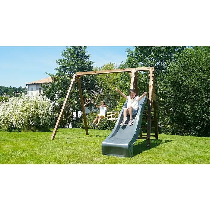 Soulet Kletterschaukel Prune - L x B x H: 351 x 261 x 224 cm, Holz - Eine Kinderspielplatzstruktur mit Rutsche und Schaukel, auf der zwei Kinder spielen, eingebettet in einen üppigen grünen Garten.