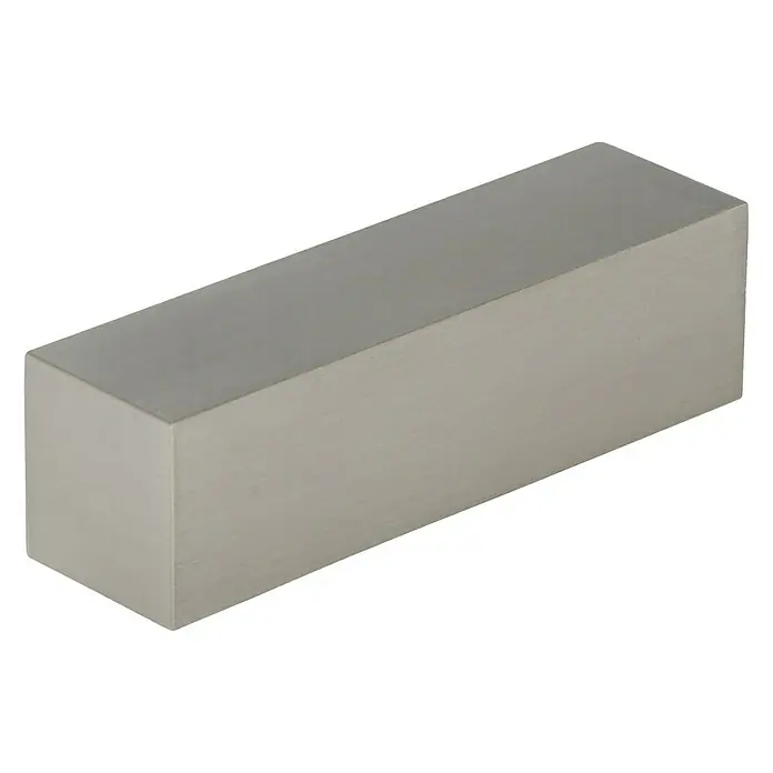 Expo Ambiente Endstück Next - Edelstahloptik, 16 mm - Nahaufnahme eines metallischen Quaders, der auf einer ebenen Fläche liegt und dessen Oberfläche eine matte Textur aufweist.