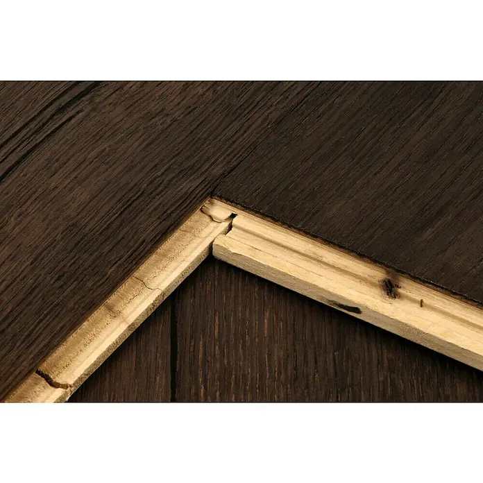 Parkett - Eiche Grindelwald, Landhausdiele, 1.900 x 190 x 15 mm - Nahaufnahme eines beschädigten Holzrahmens auf einer dunklen Holzoberfläche, die Details und Texturen hervorhebt.