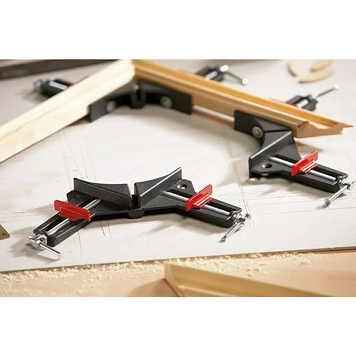 Bessey Winkelspanner WS1 - Spannweite: 73 mm - Eckspanner mit rotem Griff und Holzrahmen auf einer Werkbank. Zum präzisen Zusammenfügen von Werkstücken bei Holzarbeiten.
