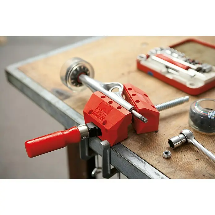 Bessey Schraubspanner S 10 - Spannweite: 100 mm - Nahaufnahme einer Schraubzwinge, die einen Skateachse auf einer Werkbank fixiert, zusammen mit Werkzeugen zur Reparatur.