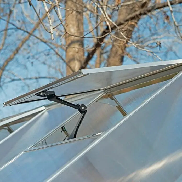 Palram – Canopia Invernadero Hybrid - Medidas ext. (An x Pr): 185 x 306 cm, 0,7 mm, Plateado - Primer plano de una ventana abierta de un invernadero con un abridor automático. La construcción es de aluminio.