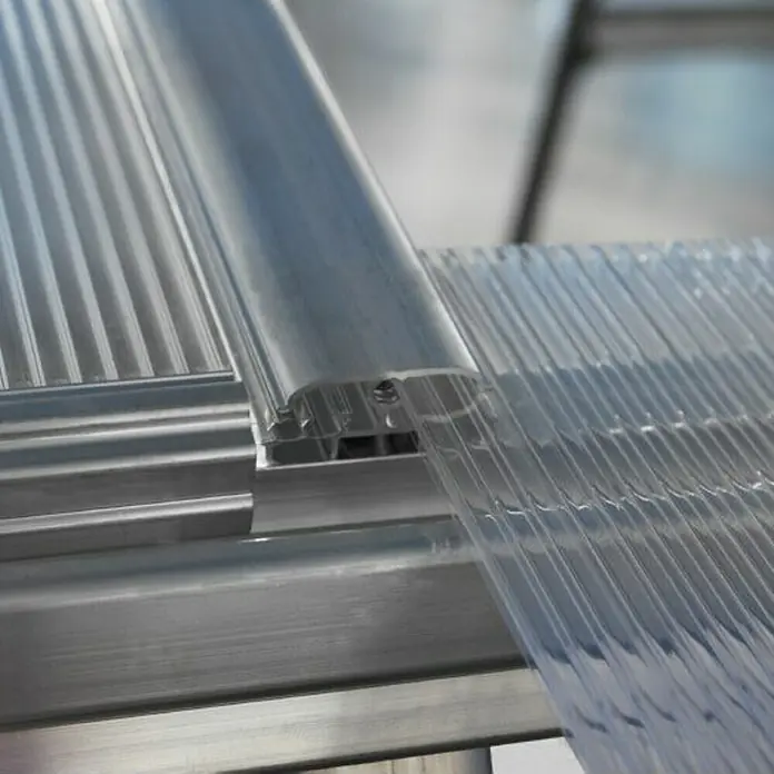Palram – Canopia Gewächshaus Hybrid - Außenmaß inkl. Dachüberstand (B x T): 185 x 306 cm, 0,7 mm, Silber - Nahaufnahme einer Polycarbonat-Wellplatte, die mit einem Aluminiumprofil befestigt ist, ideal für Terrassenüberdachungen und Gewächshäuser.