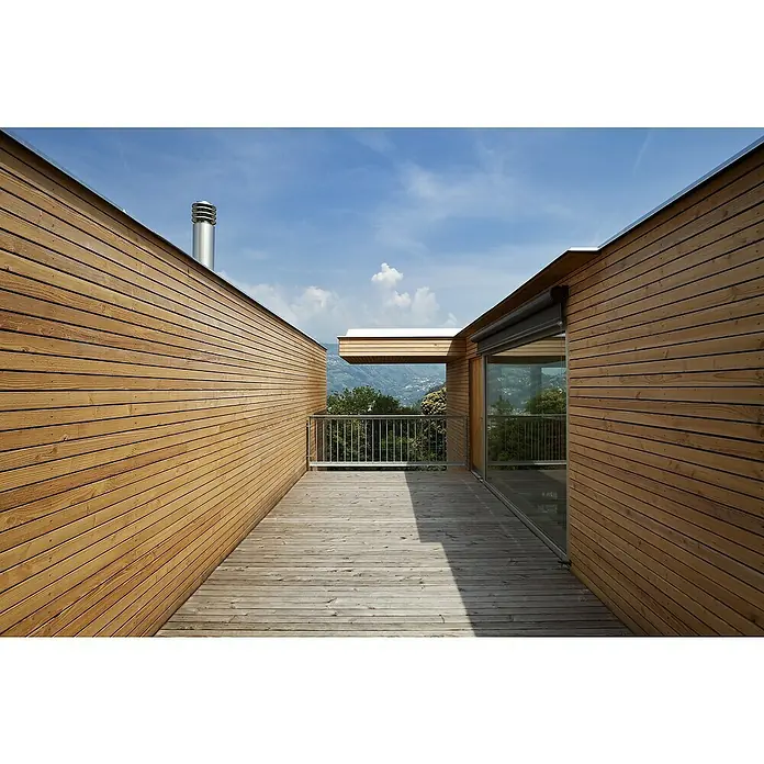Rahmenholz I300 x 7 x 3,5 cm, Douglasie, Gehobelt - Ein modern gestalteter Holzhausbalkon mit Blick auf eine grüne Landschaft und blauem Himmel bietet eine friedliche und ästhetische Szene.