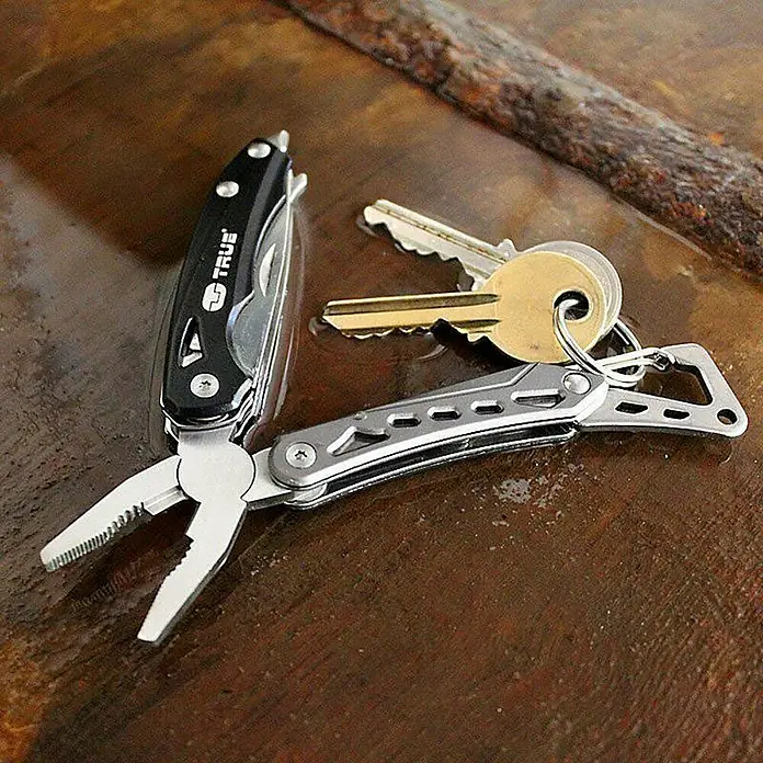 Nebo Tools Set multiherramienta y linterna - Negro - Multiherramienta con llavero y llaves, exhibida sobre una superficie de madera, perfecta para llevar a diario.