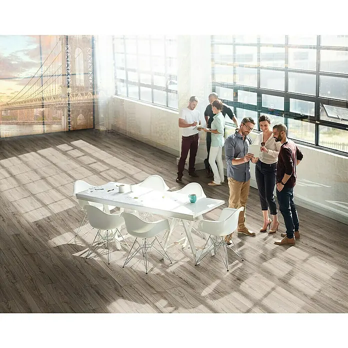 MyStyle MyDream Laminat - Rutherford Oak, Landhausdiele, 1.285 x 192 x 14 mm - Ein helles, modernes Büro mit einem langen, weißen Tisch und stilvollen Stühlen. Der Bodenbelag ist aus hellem Holz, das dem Raum eine warme Atmosphäre verleiht.