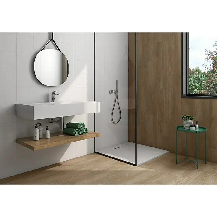 Pavimento porcelánico Alcázar - 20 x 75 cm, Nut, Mate - El baño presenta un lavabo moderno con un espejo redondo y una cabina de ducha con detalles de madera para un ambiente elegante.