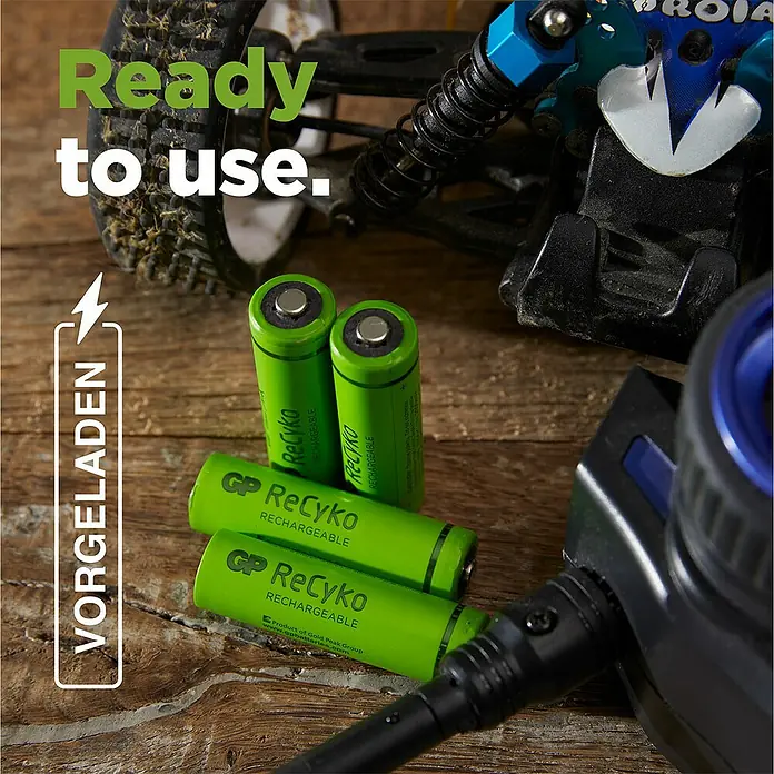 GP ReCyko Akku AA Mignon/HR6, 2100 mAh, NiMH, Ready-to-use 8Stk - 2.100 mAh - Das Bild zeigt GP ReCyko Akkus vor einem Modellauto, die "gebrauchsfertig" sind, und hervorgehobene Akkuladefunktion.
