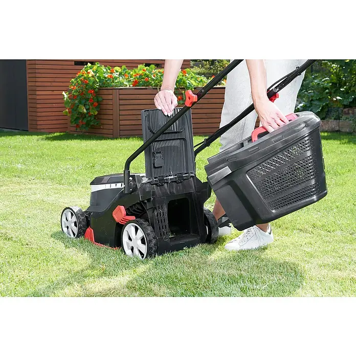AL-KO Bosch Home & Garden Compatible Akku-Rasenmäher 3.22 Li Easy - 18 V, 2 Akkus, 2,5 Ah, Schnittbreite: 32 cm - Eine Person befestigt einen Grasfangkorb an einem Rasenmäher auf einem Rasen.