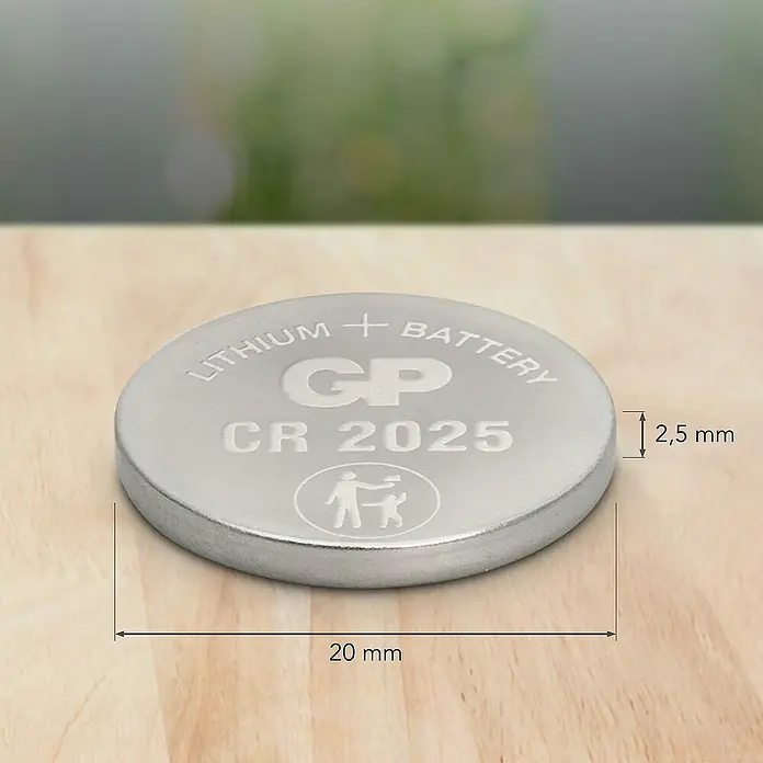 GP Lithium Batterie Knopfzellen CR2025 3V - 5 Stk. - Nahaufnahme einer Knopfzelle GP CR 2025 Lithium-Batterie mit den Maßen 20 mm Durchmesser und 2,5 mm Dicke auf einem Holztisch.
