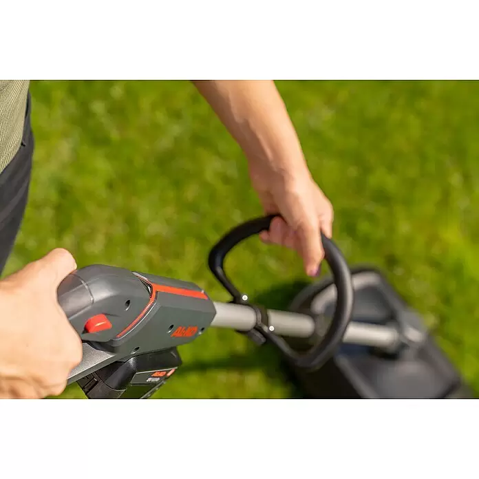 AL-KO Bosch Home & Garden Compatible Akku-Rasenlüfter AR 1835 SET - Anzahl Akkus: 1 Akku, 18 V, Arbeitsbreite: 35 cm - Nahaufnahme einer Person, die einen grau-orangen AL-KO Rasentrimmer zur Gartenpflege hält.
