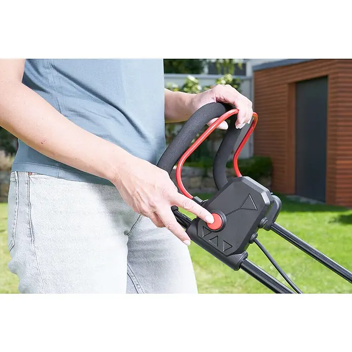 AL-KO Bosch Home & Garden Compatible Akku-Rasenmäher 3.22 Li Easy - 18 V, 2 Akkus, 2,5 Ah, Schnittbreite: 32 cm - Eine Person bedient einen Rasenmäher mit einem roten Knopf zum Starten. Der Rasenmähergriff ist schwarz mit roten Akzenten.