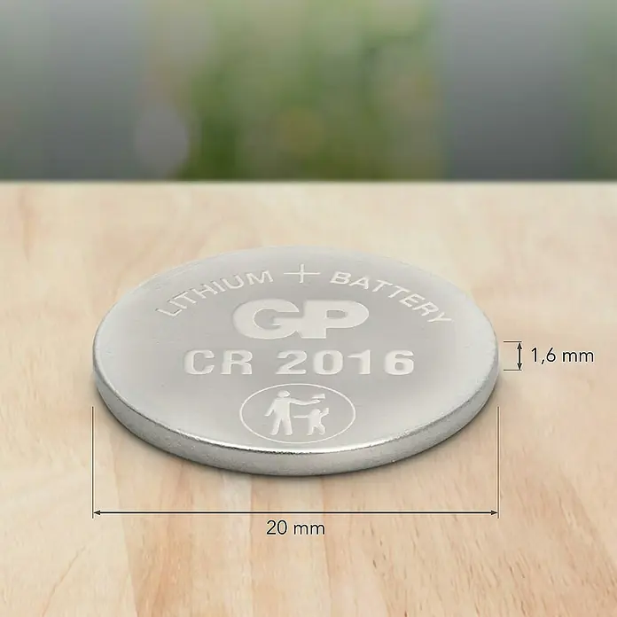 GP Lithium Batterie Knopfzellen CR2016 3V - 5 Stk. - Nahaufnahme einer Lithium Knopfzelle CR 2016 von GP mit den Maßen 20 mm Durchmesser und 1,6 mm Dicke, auf einem Tisch liegend.