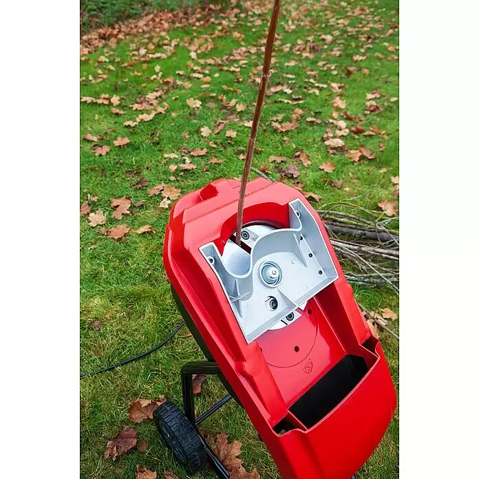 AL-KO Easy Elektro-Häcksler MH2500 Slice - Max. Aststärke: 4 cm, 2.500 W - Roter Holzhäcksler mit einem Ast, der in die obere Öffnung geführt wird.
