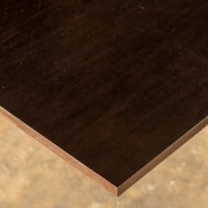 Tablero contrachapado fenólico - Abedul, 2.500 x 1.250 x 15 mm - Primer plano de un panel de madera oscura, resaltando la textura y el borde del material. Ideal para proyectos de muebles o construcción.