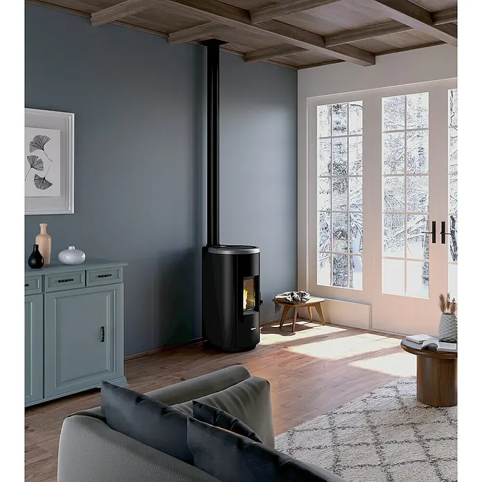 FreePoint Pelletofen Chrome 7 Airtight - 2,5 kW - 7,7 kW, Raumheizvermögen: 55 m³ - 168 m³, Schwarz, Farbe Verkleidung: Titanium - Ein stilvoller Kaminofen in Schwarz, der Wärme und Eleganz in ein gemütliches Wohnzimmer bringt. Der Ofen steht vor einer grauen Wand und großen Fenstern.