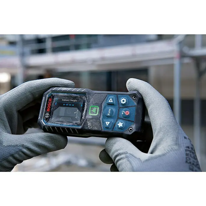 Bosch Professional Laserentfernungsmesser GLM 50-25 G - Messbereich: 0,05 - 50 m - Nahaufnahme eines Bosch-Laserentfernungsmessers in Händen mit grauen Handschuhen, der "Indirekte Höhe" auf dem Display anzeigt.