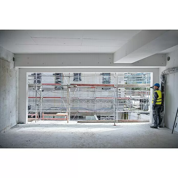 Bosch Professional Laserentfernungsmesser GLM 50-25 G - Messbereich: 0,05 - 50 m - Bauarbeiter in Schutzkleidung blickt aus Fenster auf Baugerüst auf Baustelle.