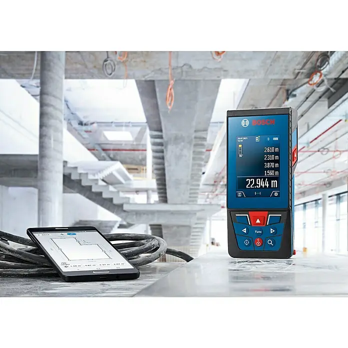 Bosch Professional Laserentfernungsmesser GLM 100-25 C - Messbereich: 0,08 - 100 m - Das Bild zeigt einen Bosch-Laser-Entfernungsmesser und ein Tablet auf einer Baustelle, ideal für präzise Messungen.