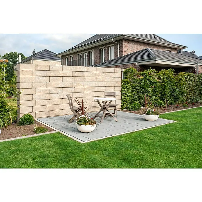 Diephaus Gehwegplatte60 x 30 x 4 cm, Grau, Beton - Bild einer modern gestalteten Gartenterrasse mit Steinmauer, Sitzgruppe und üppigem Grün. Die Terrasse lädt zum Verweilen im Freien ein.